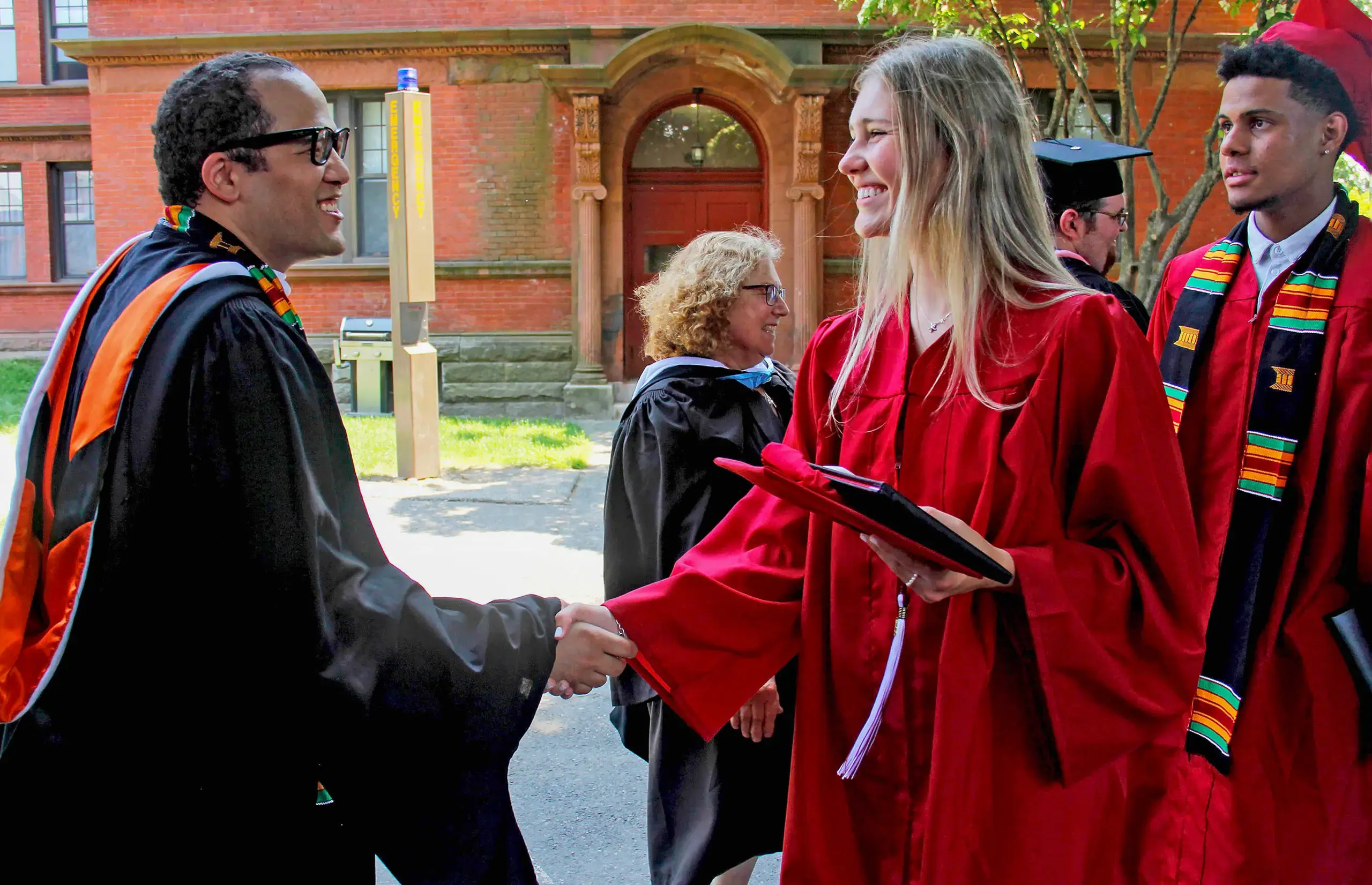 Teacher and student shake hands at Graduation 2024.