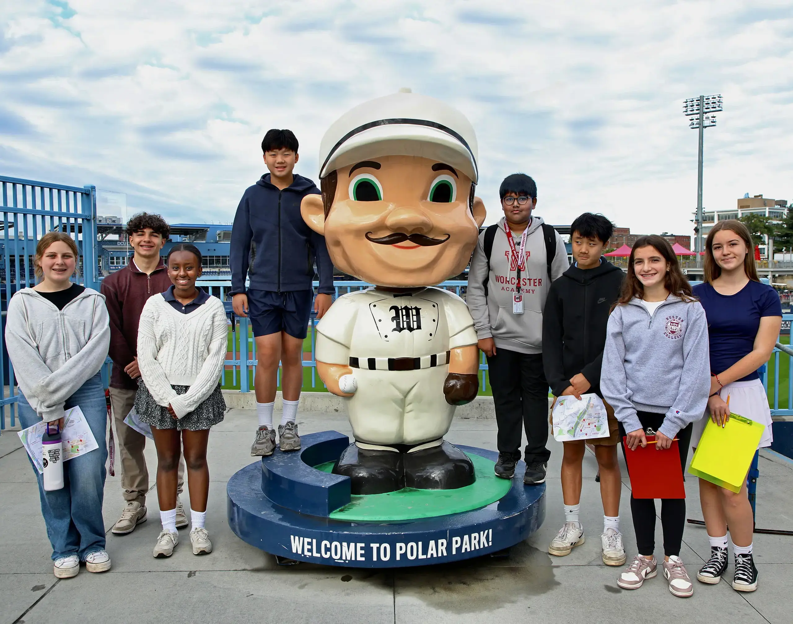 Middle School students in the city at Polar Park standing near a statue.