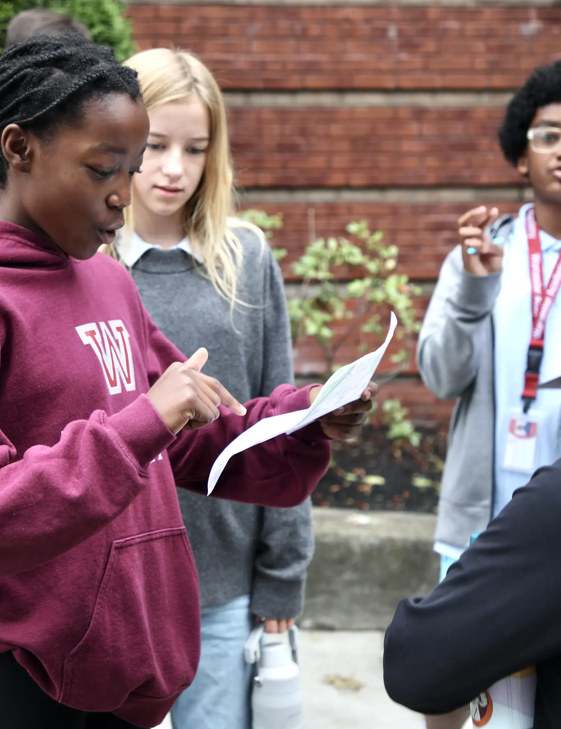 A group of students standing together looking at a paper