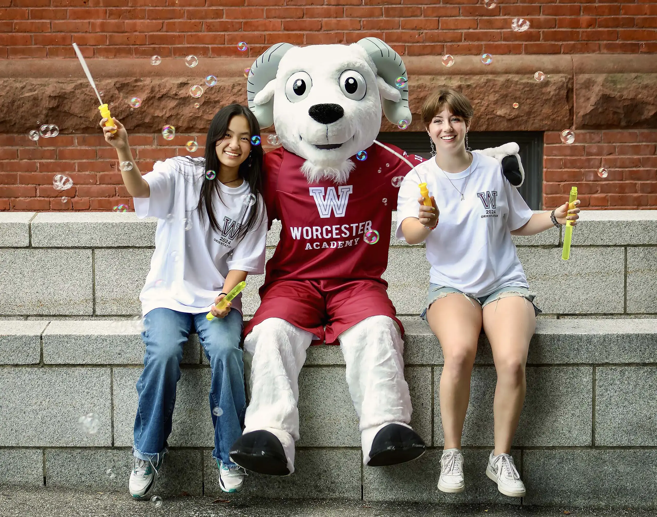 Worcester Academy students sitting with the mascot.