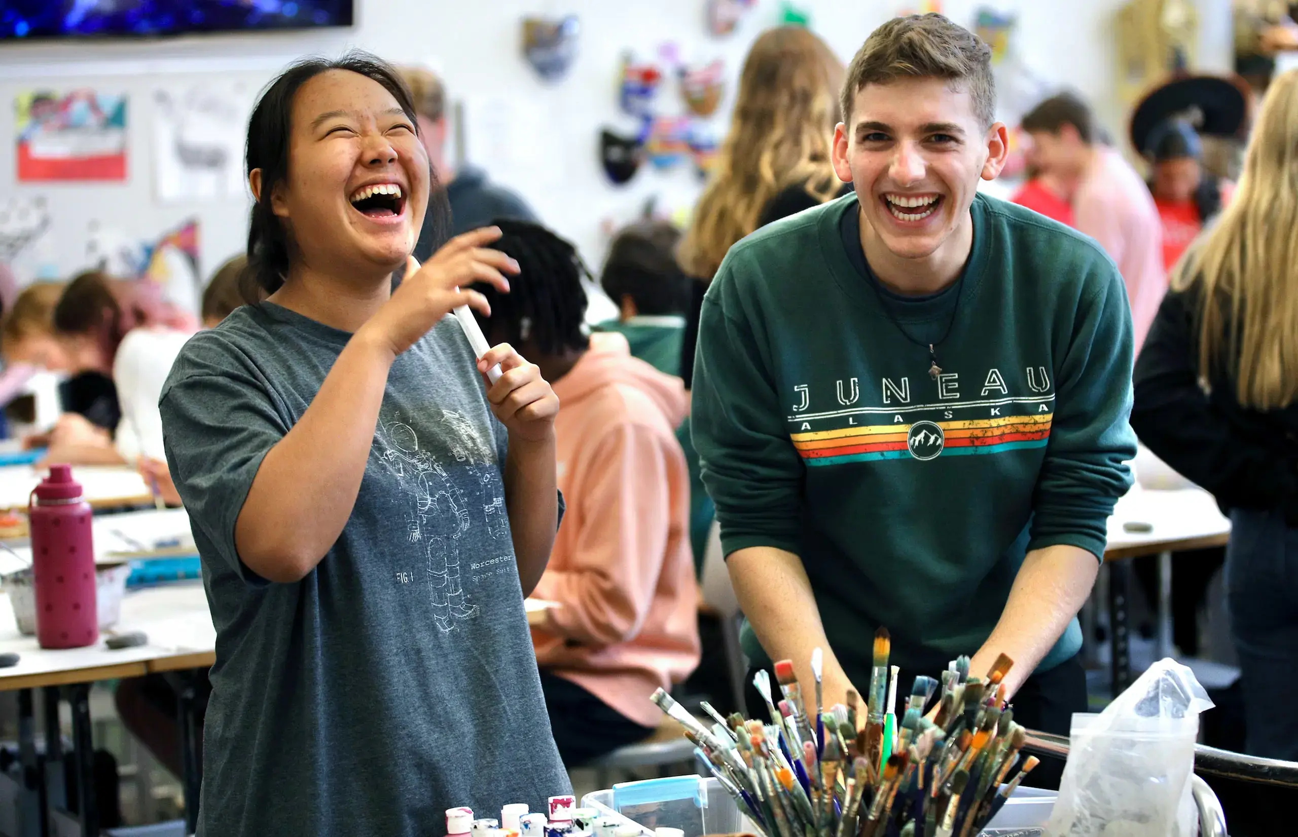 Two Upper School students laughing in art class