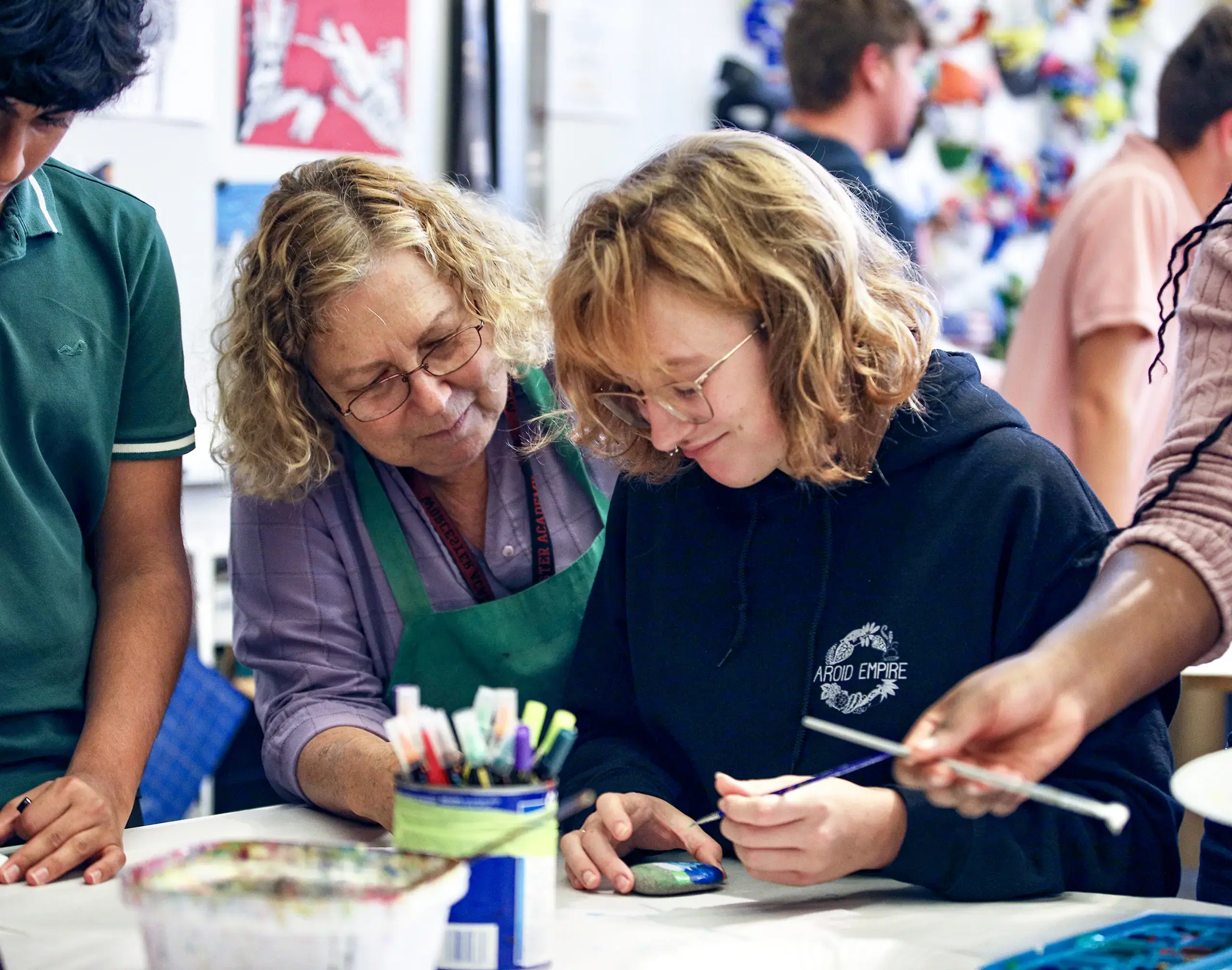 Worcester Academy Upper School art student and teacher working at a table.