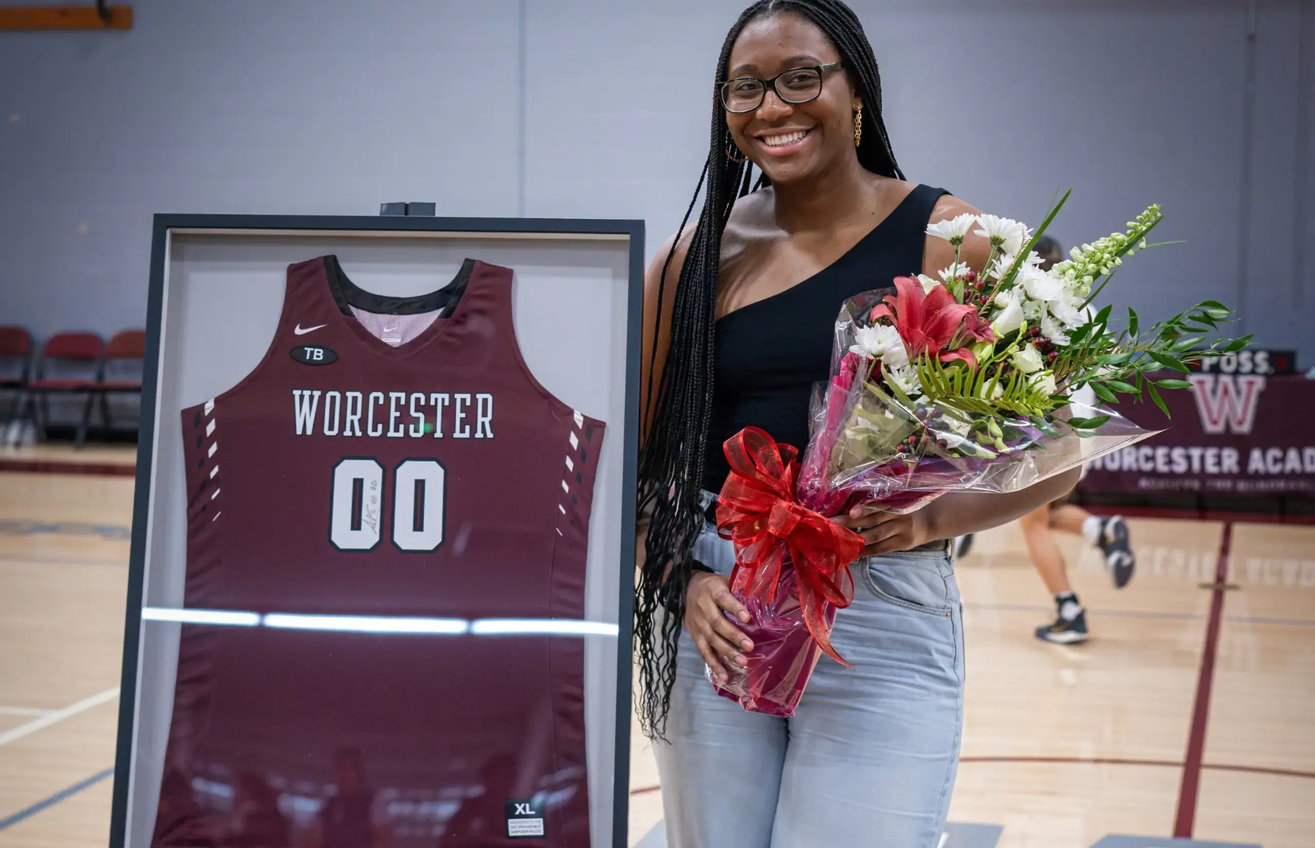 Worcester Academy Alumni Athlete with a framed jersey and holding flowers. 