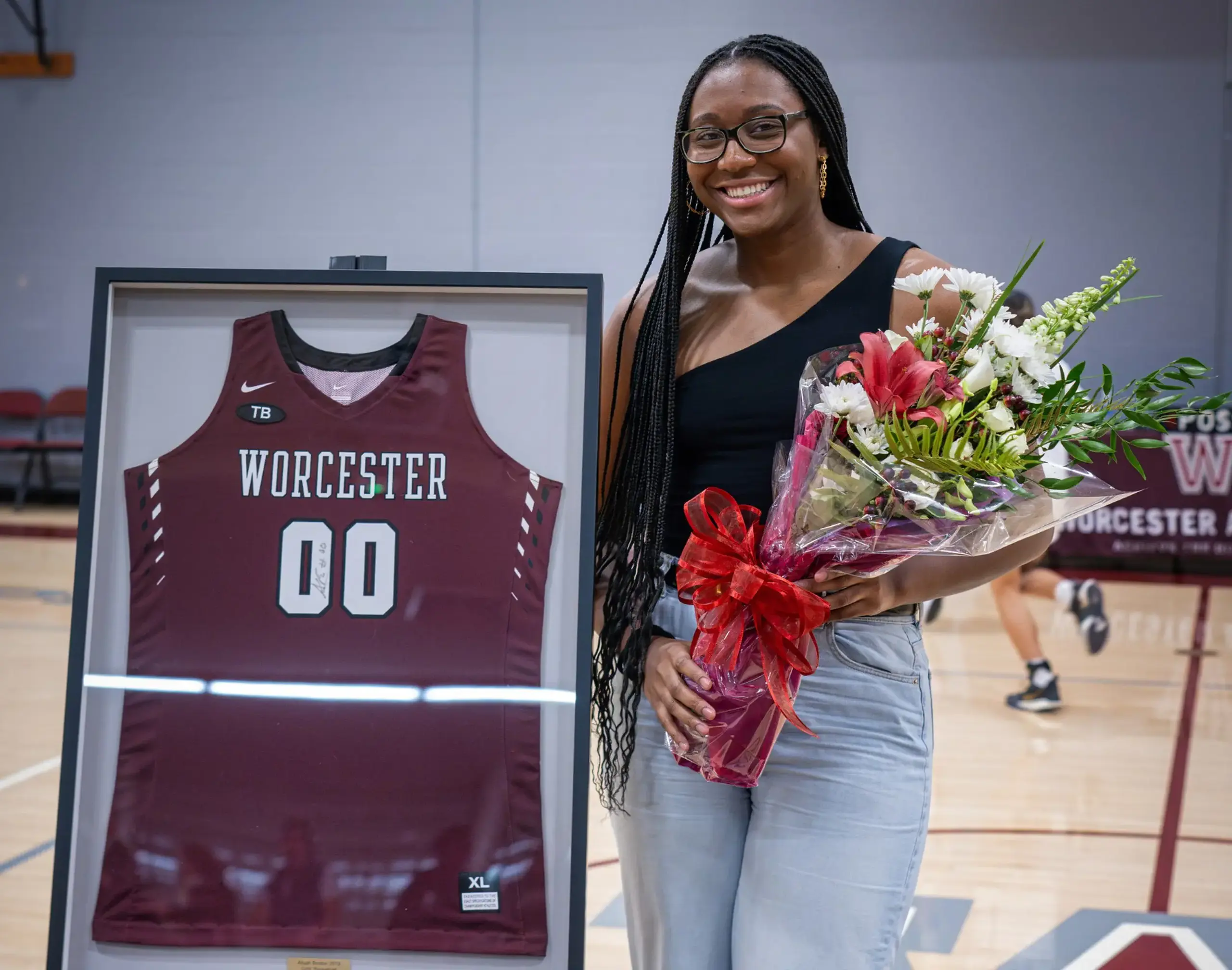 Worcester Academy Alumni Athlete with a framed jersey and holding flowers. 