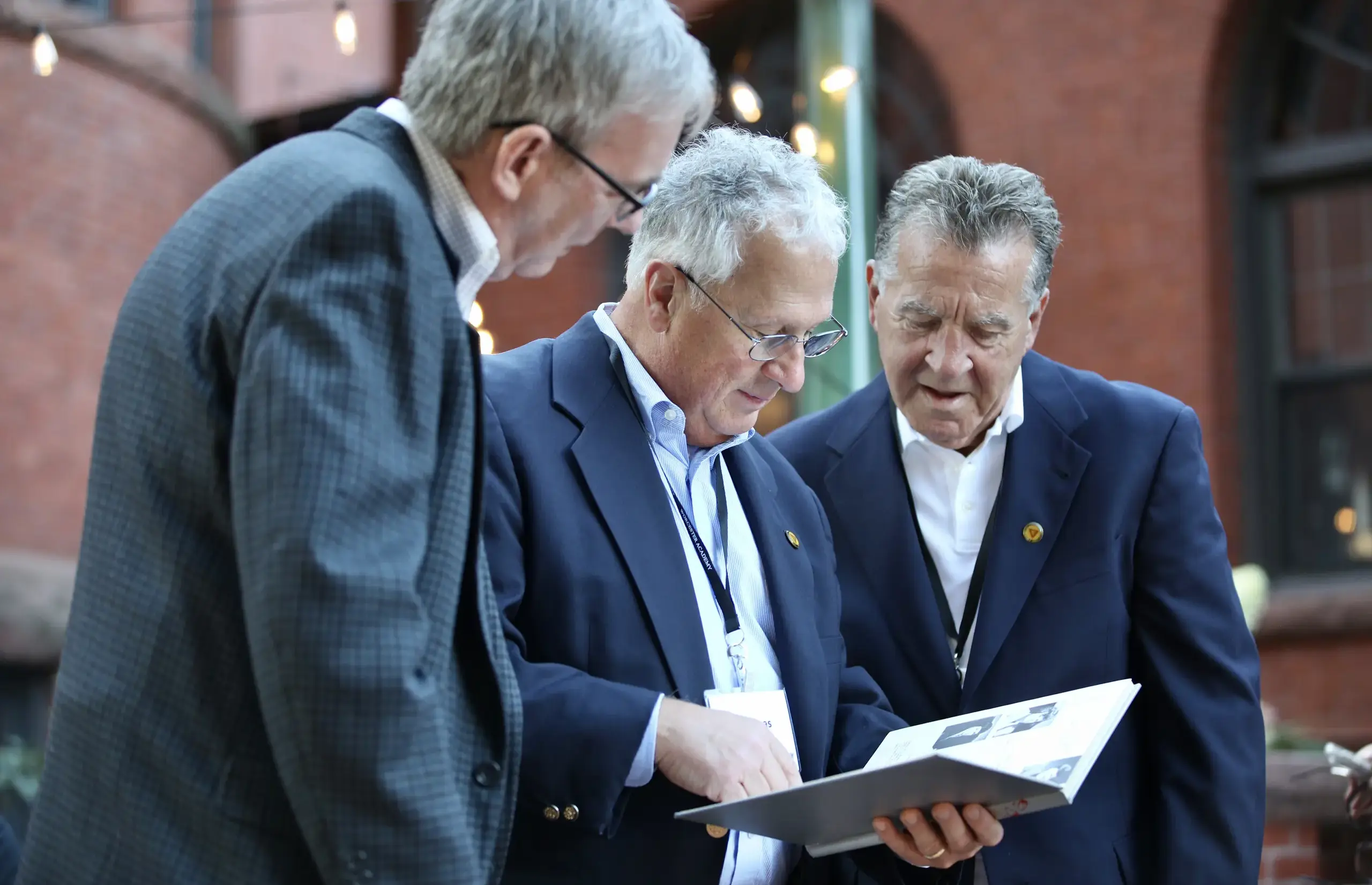 Worcester Academy Alumni looking at a yearbook.