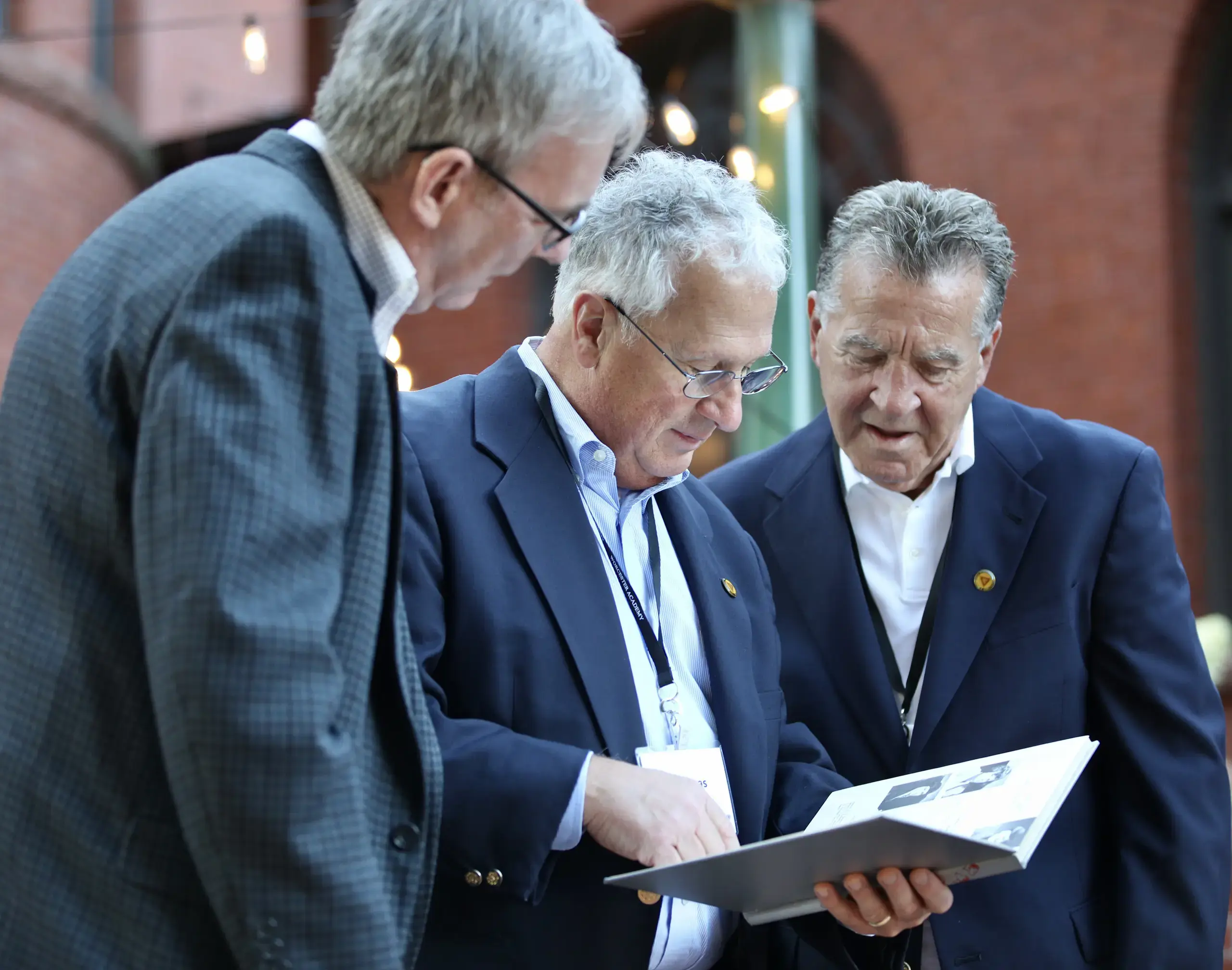 Worcester Academy Alumni looking at a yearbook.