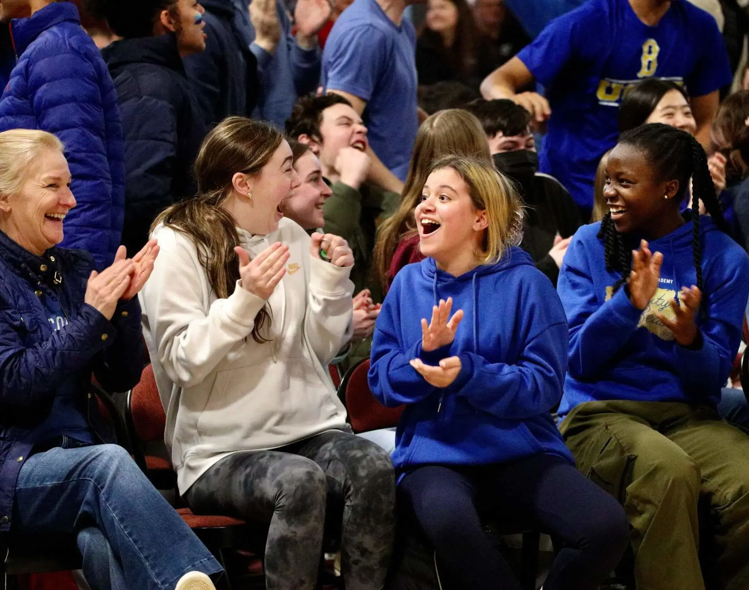 Worcester Academy students watching an athletics match and cheering