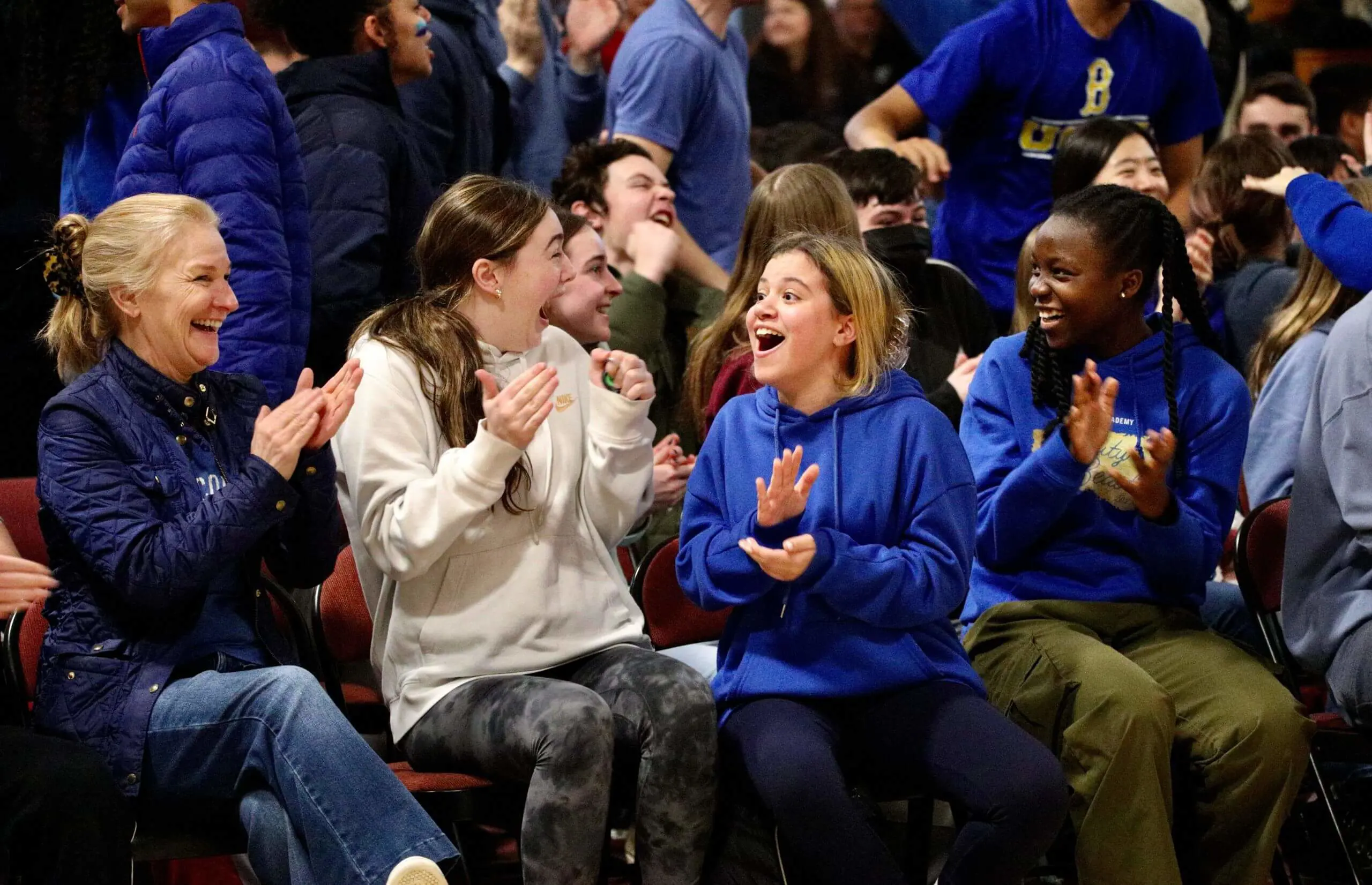 Worcester Academy students watching an athletics match and cheering