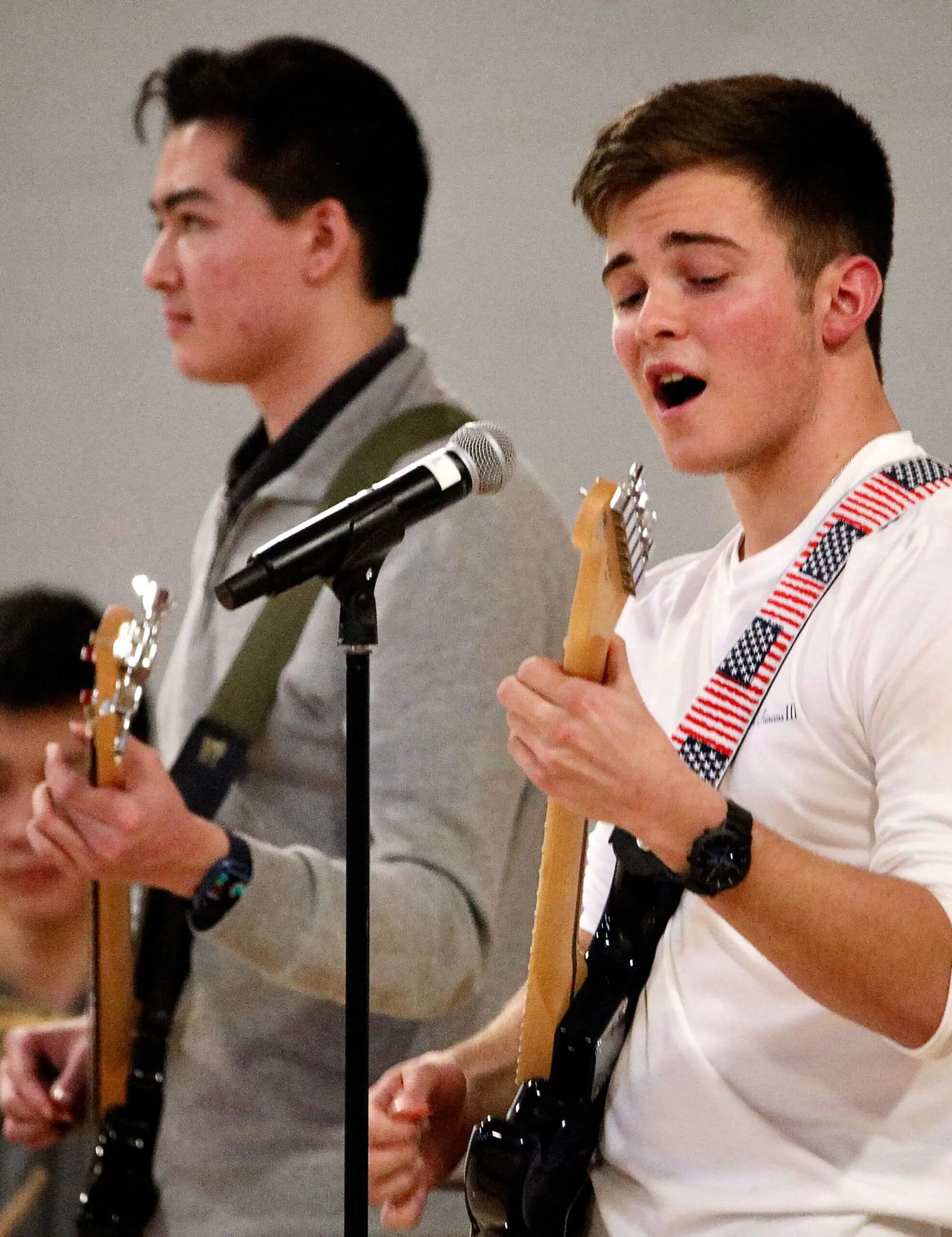 Worcester Academy Upper School student playing guitar and singing.