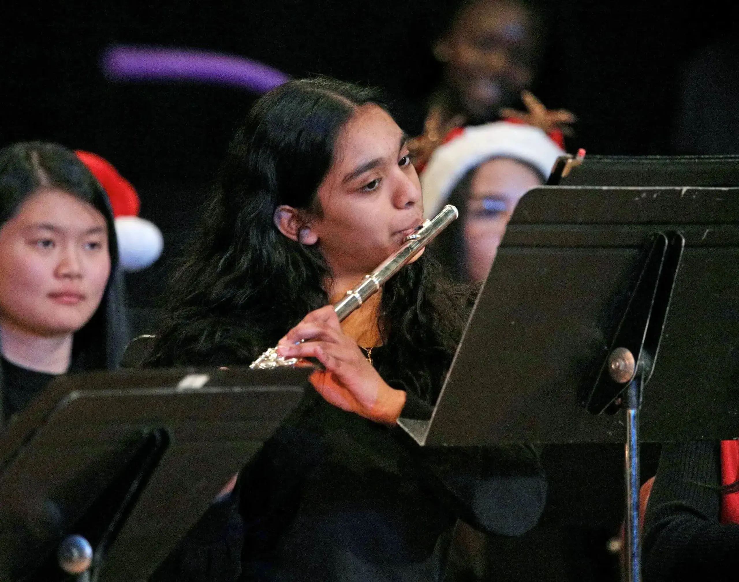 Worcester Academy Student flautist playing with the orchestra in a school concert.