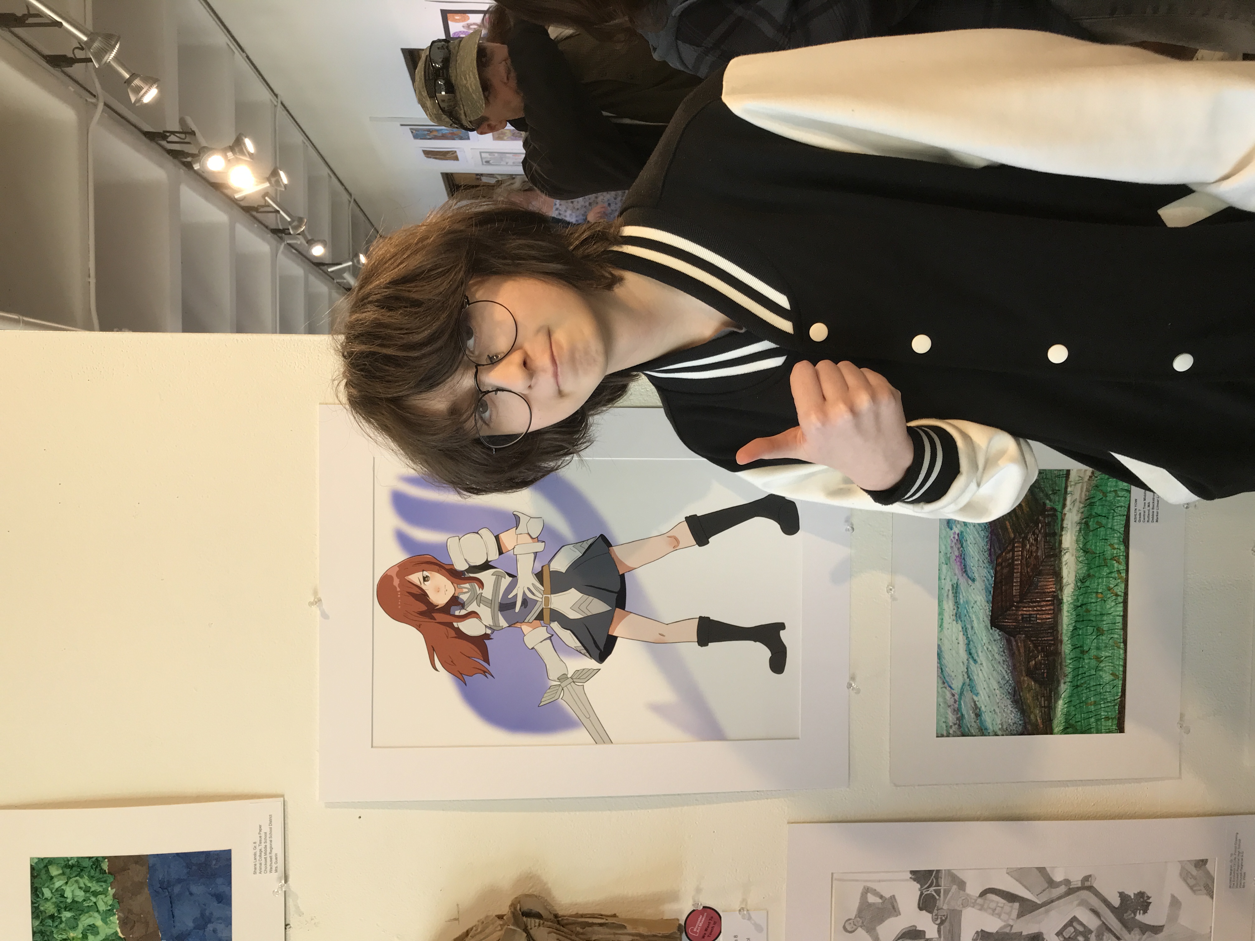 Worcester Academy student with their art on display at a gallery.