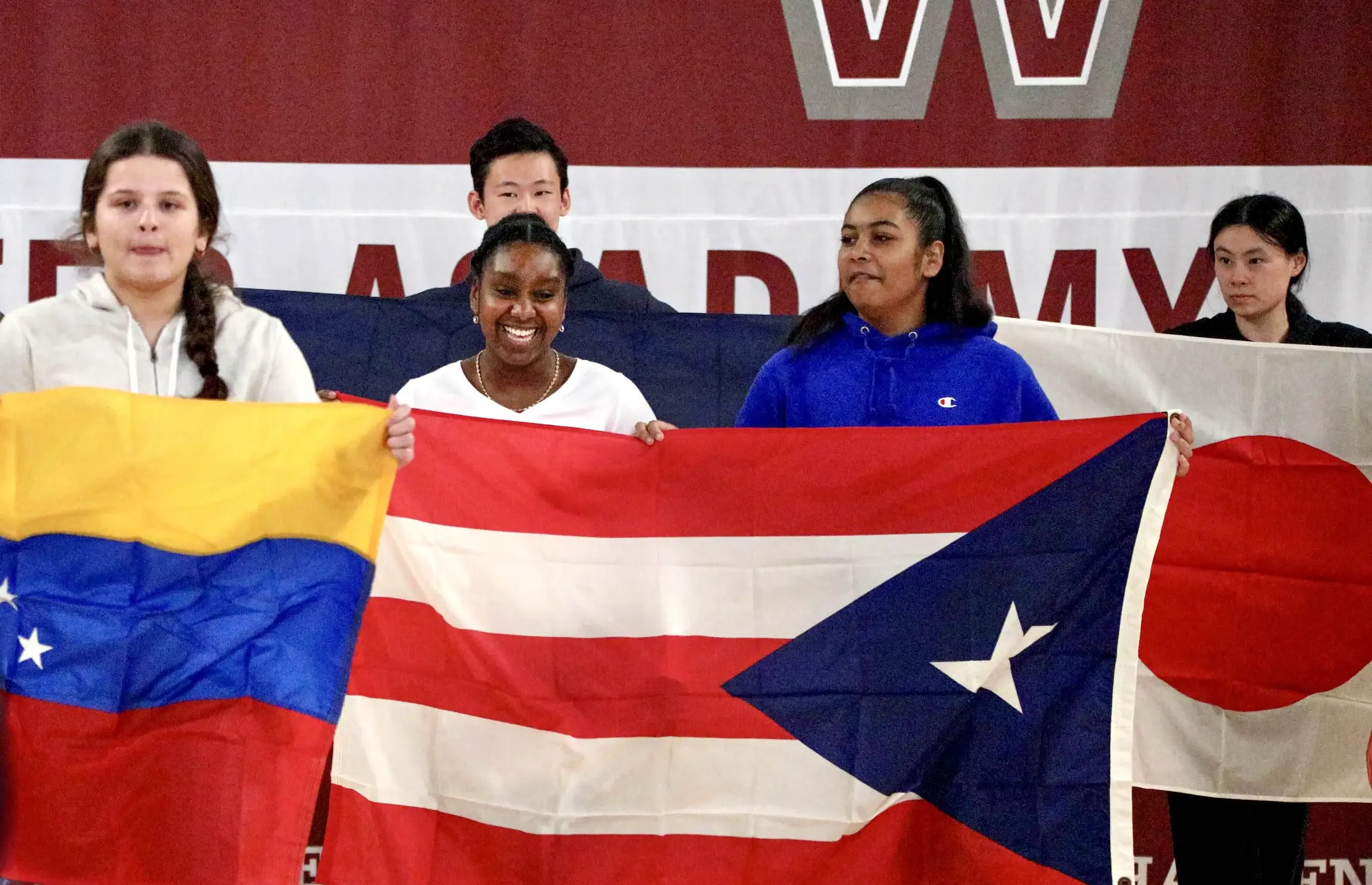 Worcester Academy Students holding up world flags at the International Assembly.