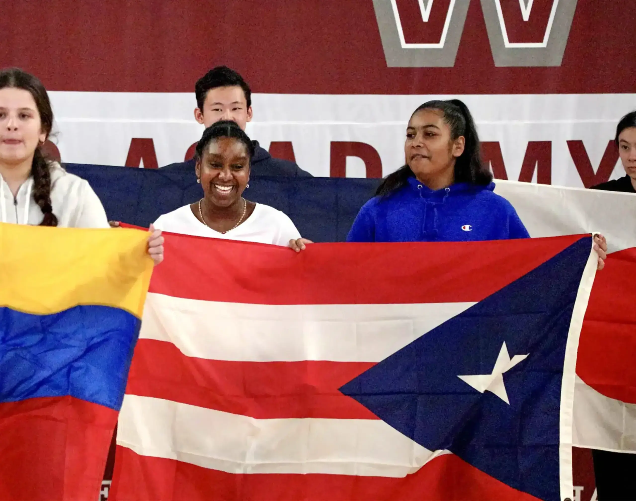 Worcester Academy Students holding up world flags at the International Assembly..