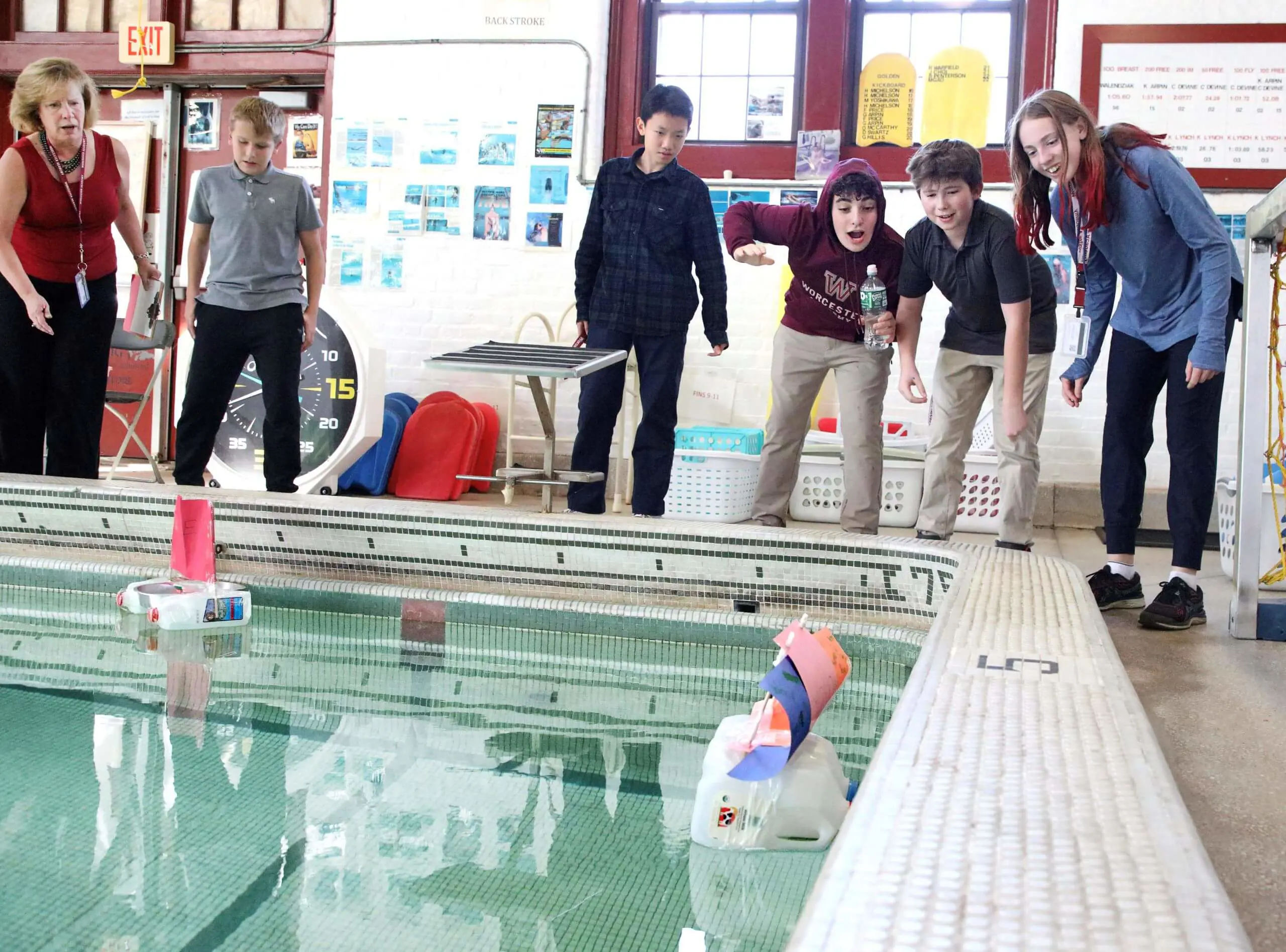 Worcester Academy Middle School students racing boats in school pool as part of a science experiment
