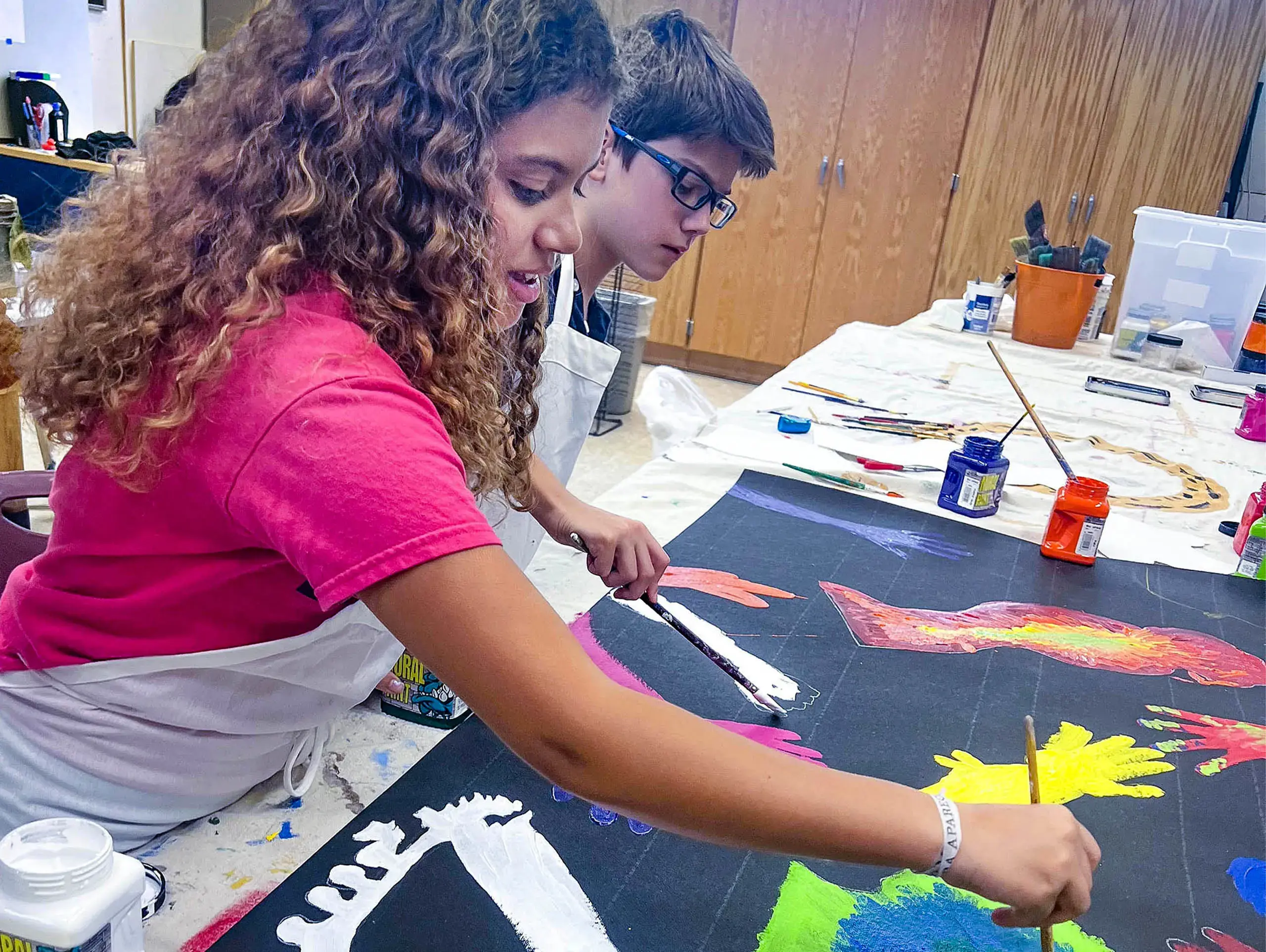 Middle School student painting in art class