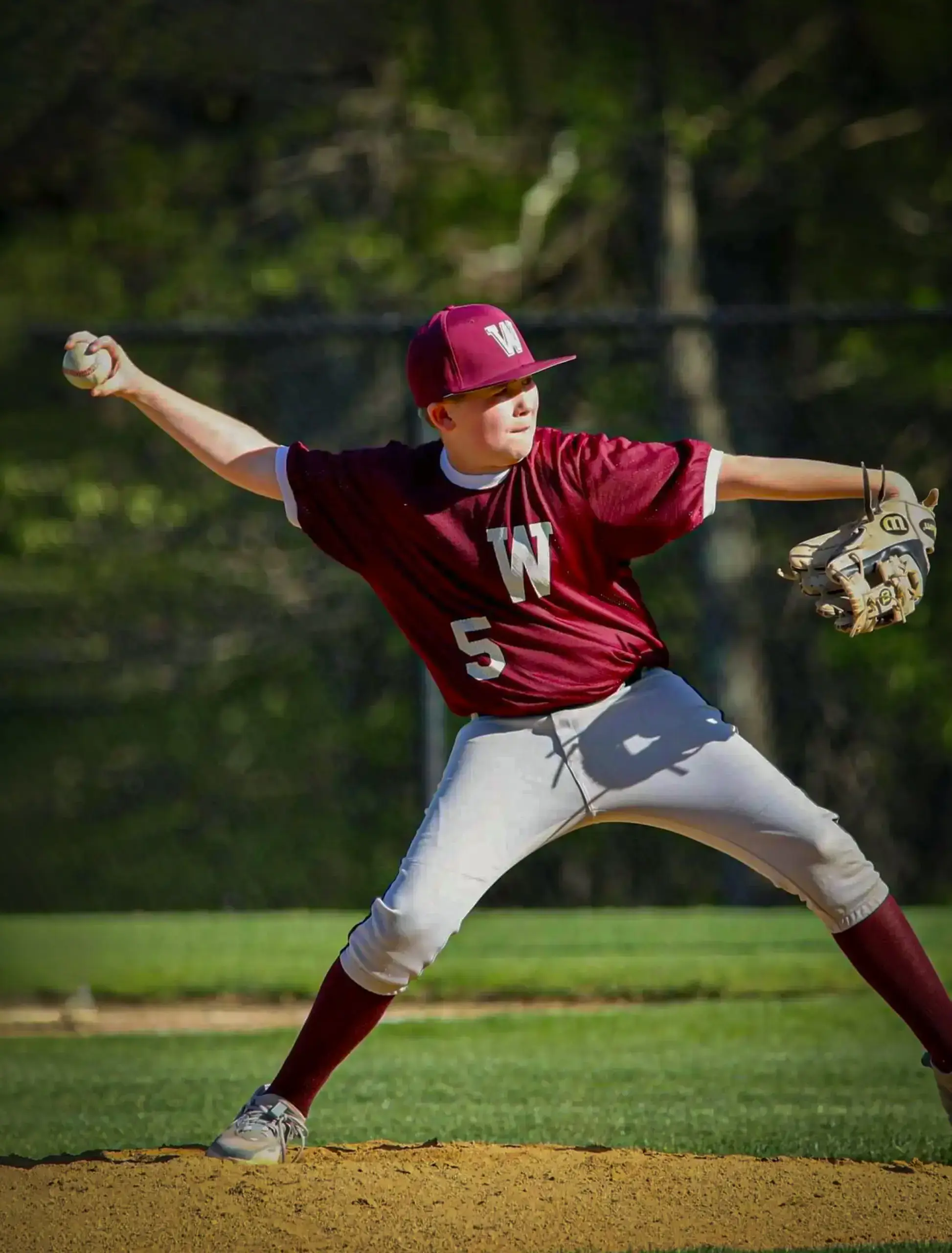 Worcester Academy Middle School student pitching a ball at a baseball game. 