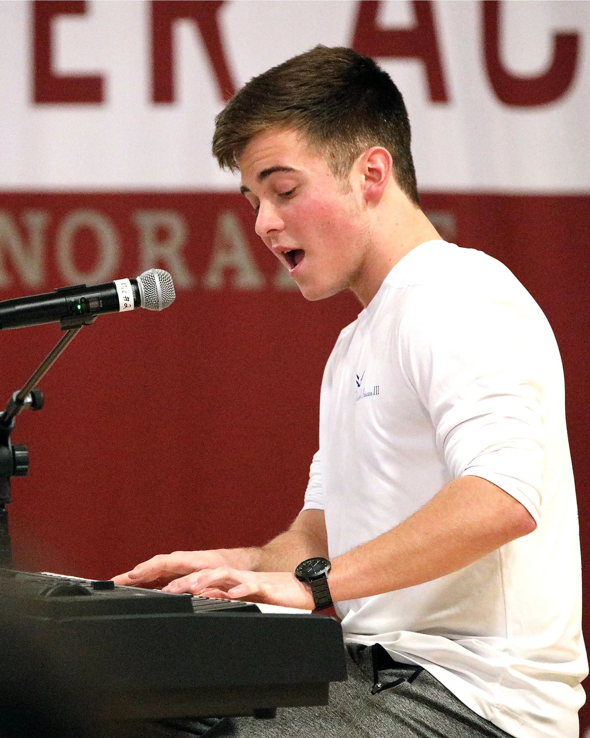 Peyton Darling ’25 singing and playing a keyboard.