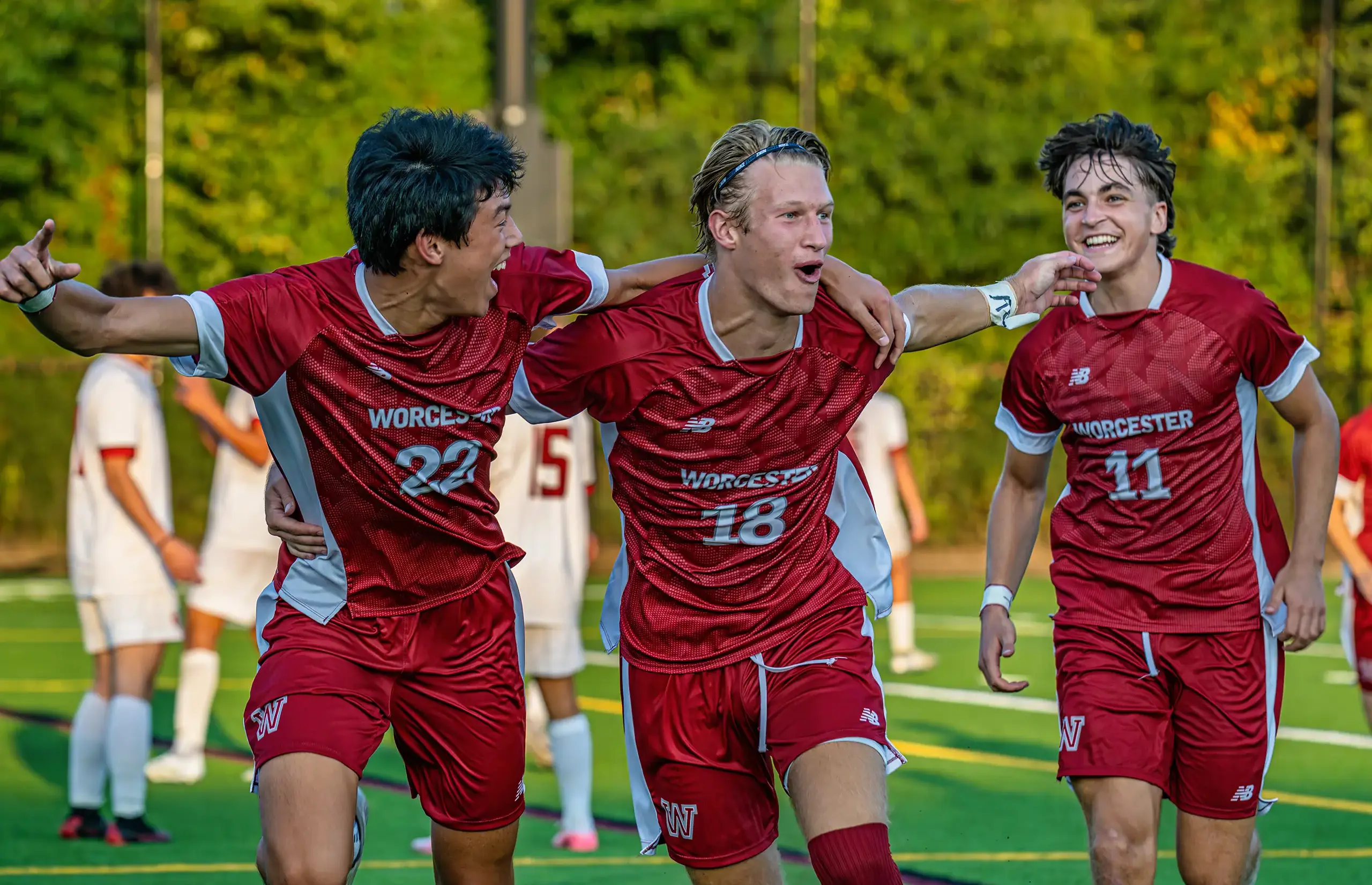 Three Worcester Academy boys celebrating a soccer match.