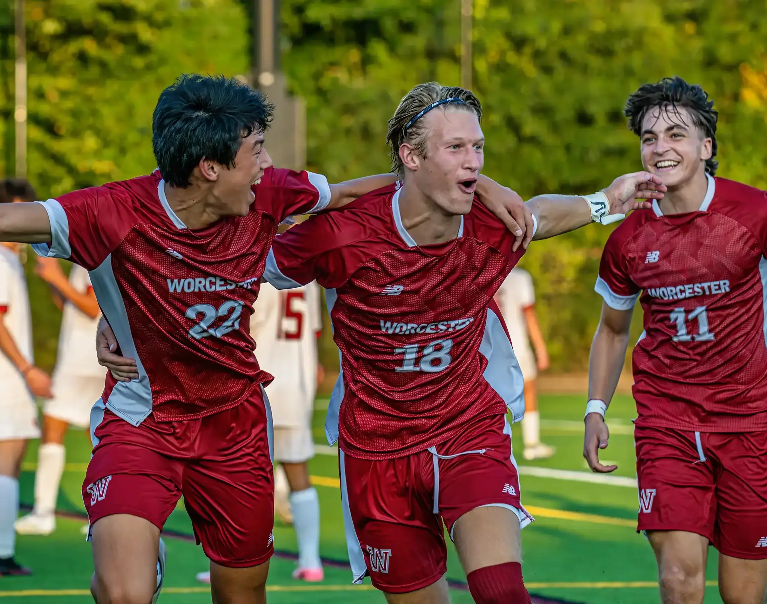 Three Worcester Academy boys celebrating a soccer match.