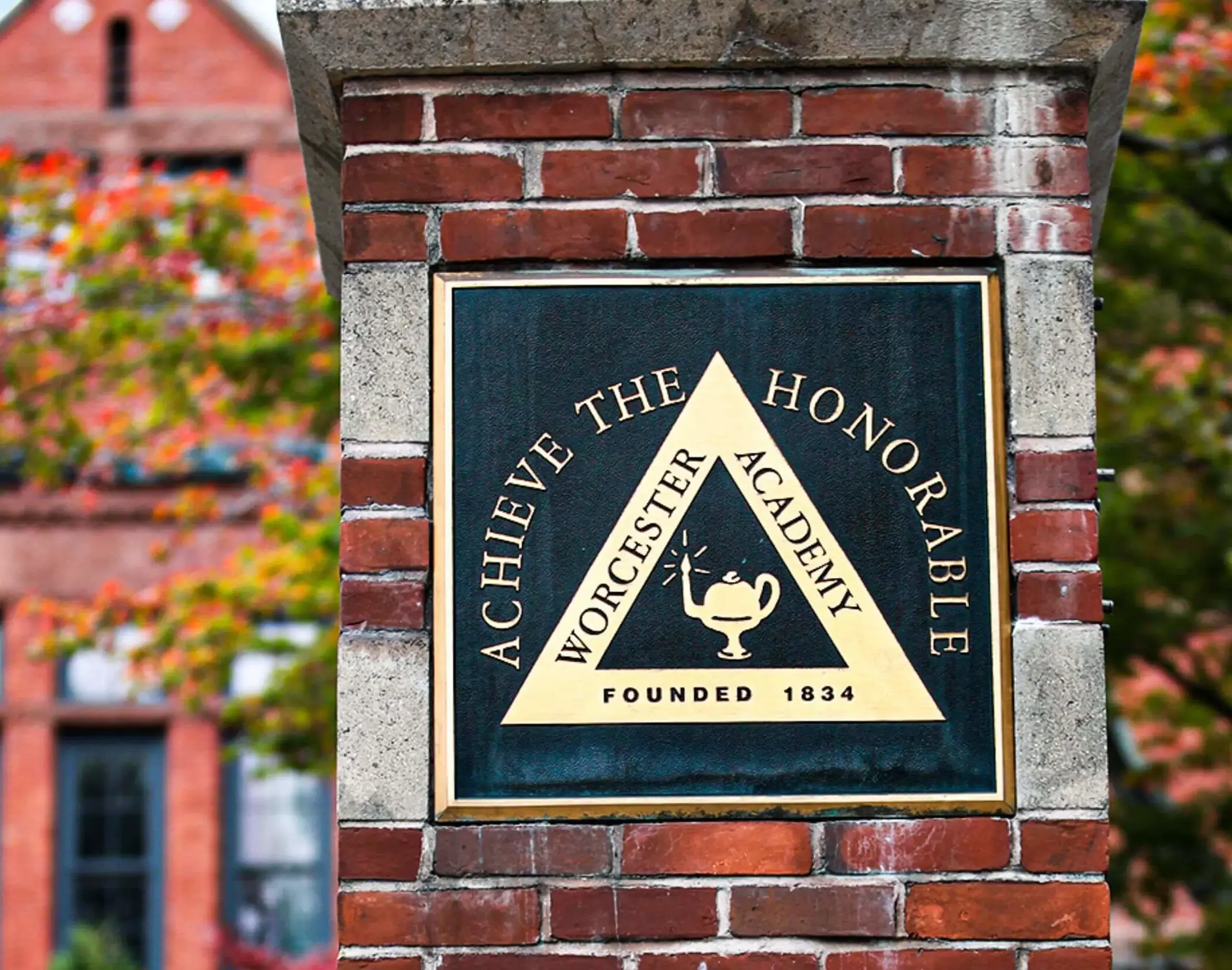 Worcester Academy 'Achieve The Honourable' plaque on a brick gate post