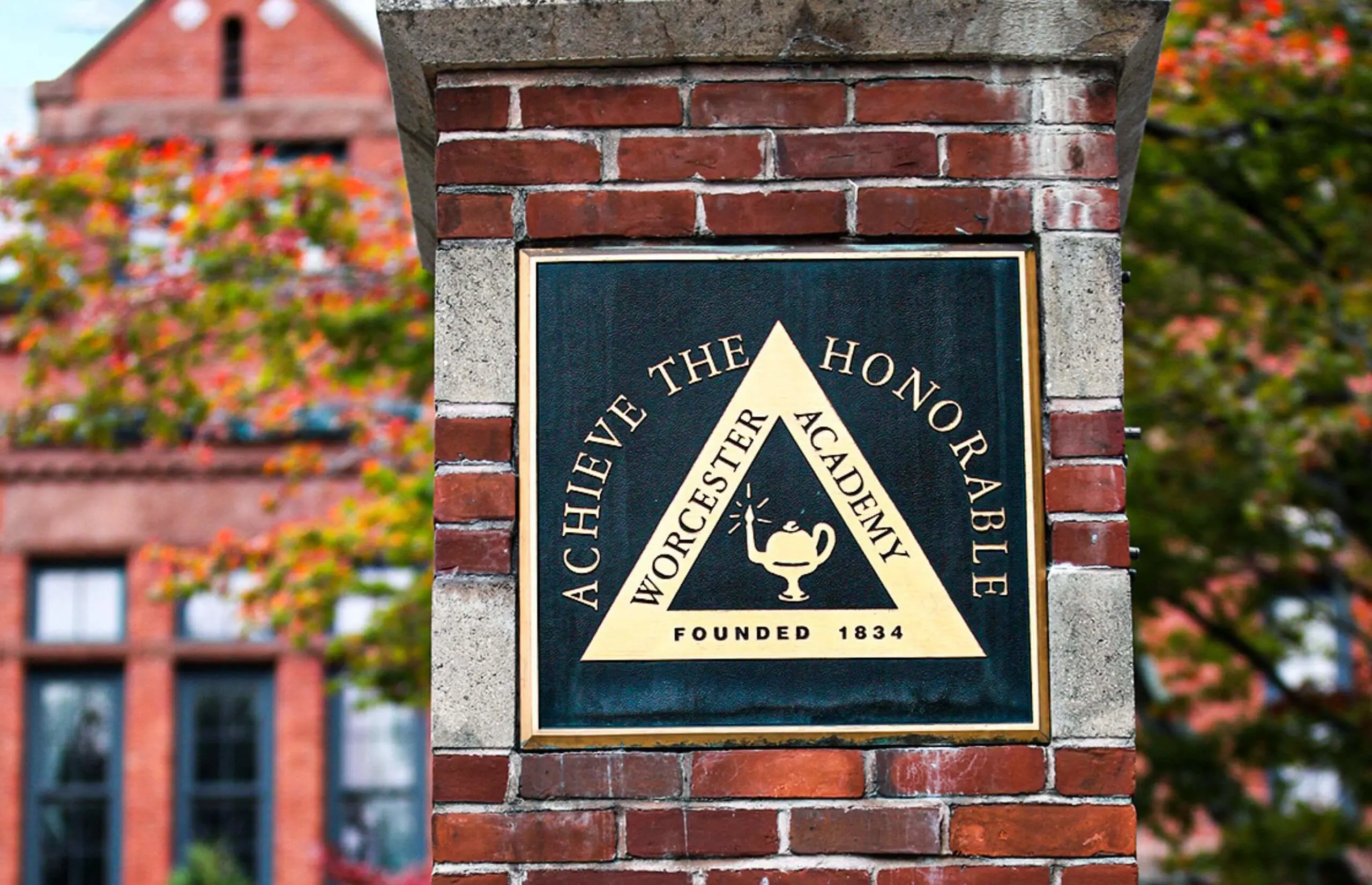 Worcester Academy 'Achieve The Honourable' plaque on a brick gate post