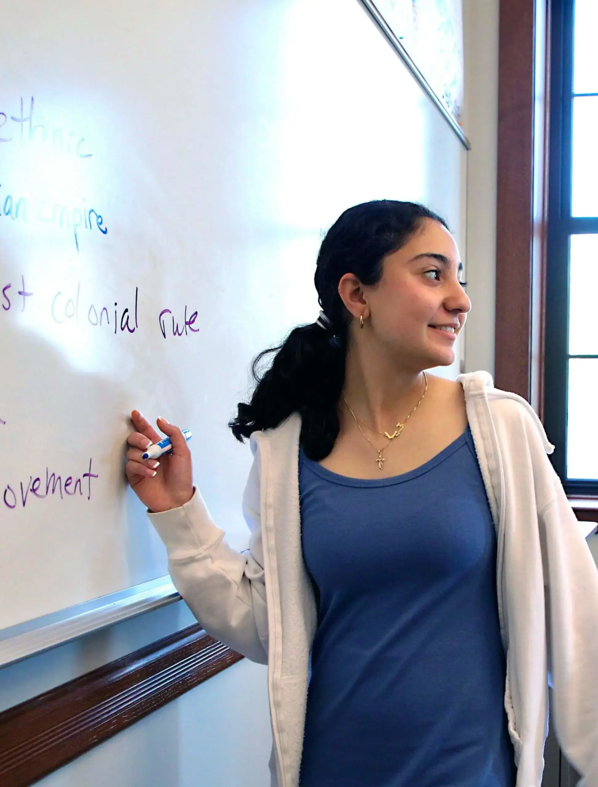 Worcester Academy Upper School student writing on the whiteboard in a history class.