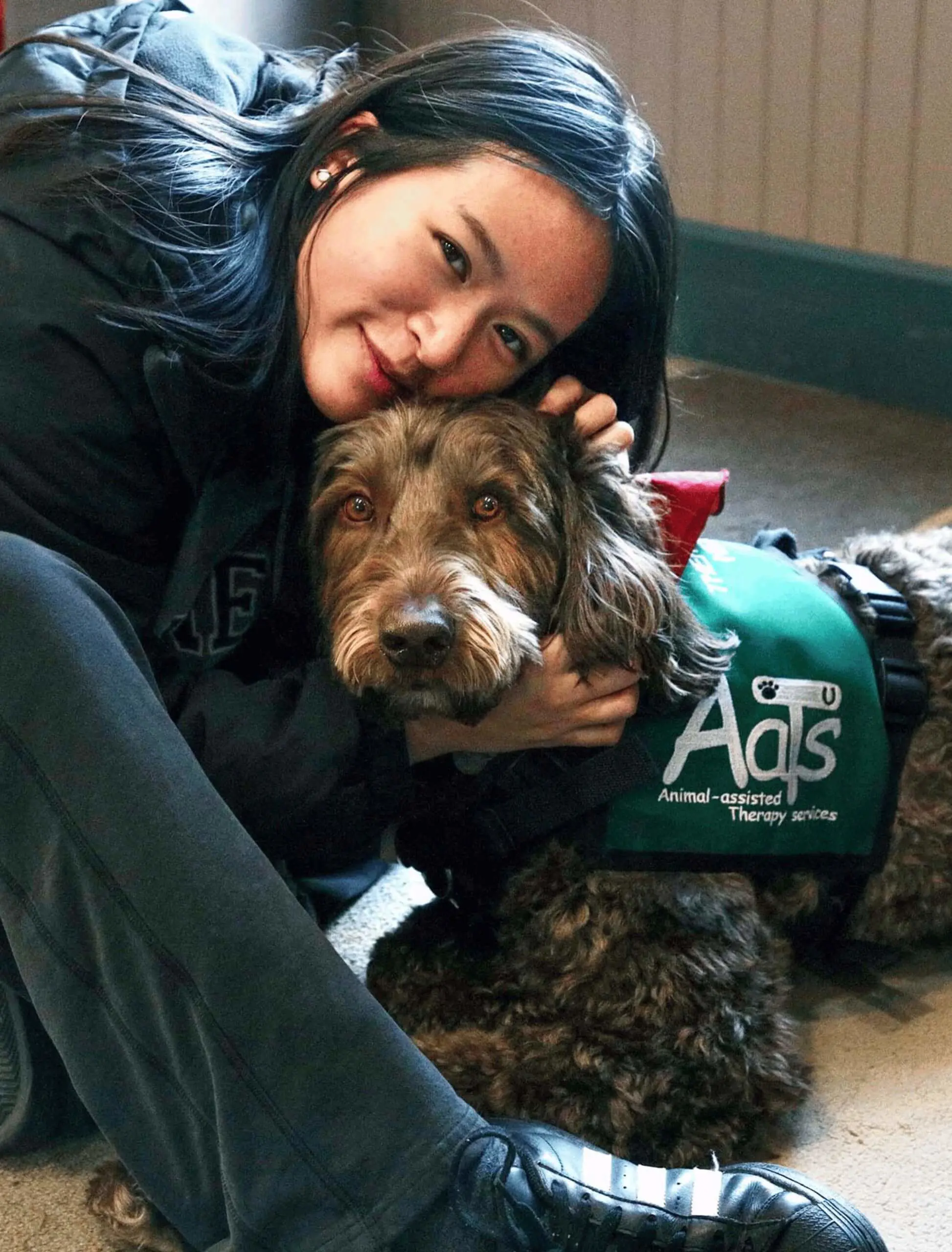 Worcester Academy student with a furry friends therapy dog on student wellness day